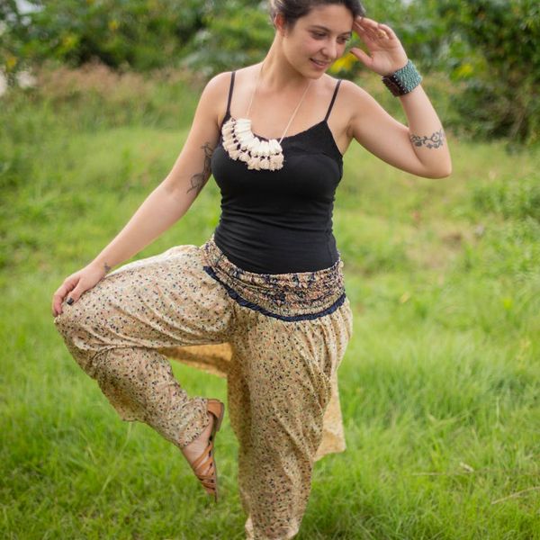 Person meditating peacefully outdoors with a serene smile.